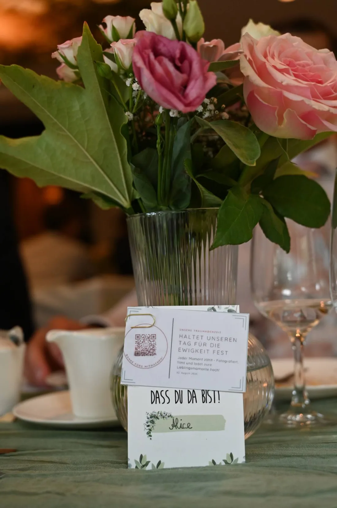 Gedruckte QR-Karte am Blumenstrauß auf einem gedeckten Hochzeitstisch